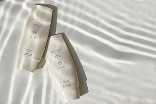 Natalie's better aging and smooth lotion lying on a beige background with water shadows