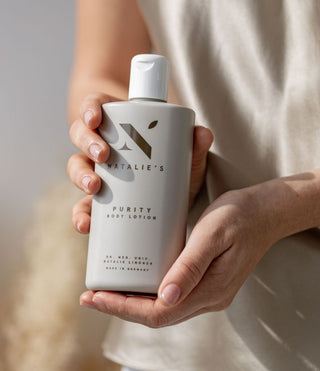 Purity body lotion held in hands